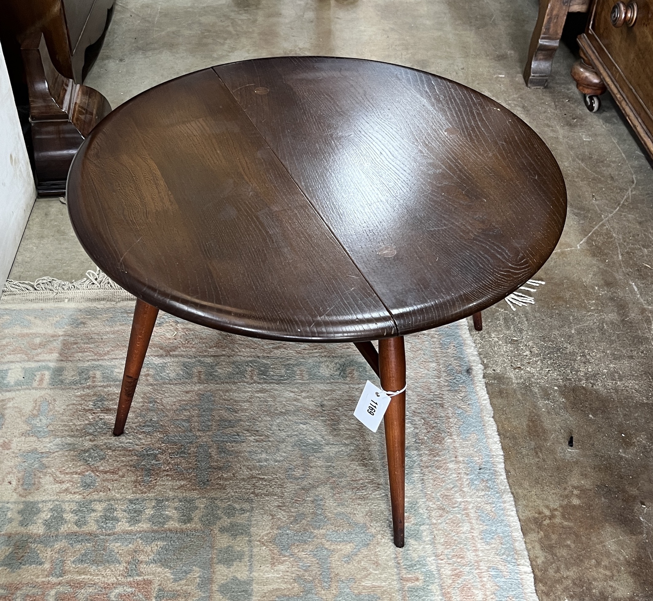 An Ercol elm single drop leaf occasional table, diameter 61cm, height 40cm
